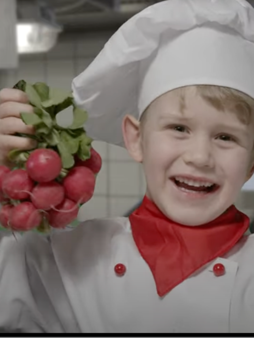 Kind mit Radieschen in der Hand