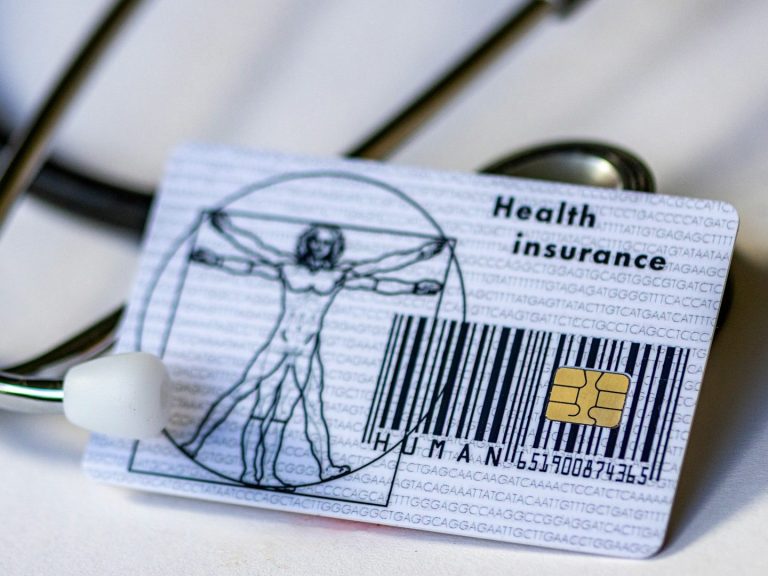 Gesundheitskarte mit Da Vinci-Motiv und Barcode, neben einem Stethoskop.